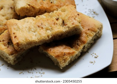 Freshly baked homemade focaccia bread on a white dish.  - Powered by Shutterstock