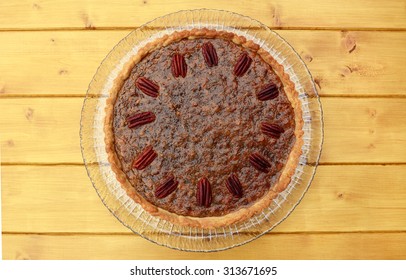 Freshly baked home-made pecan pie on a wooden table