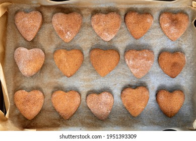 Freshly baked homemade shortbread cookies in shape of heart on baking sheet