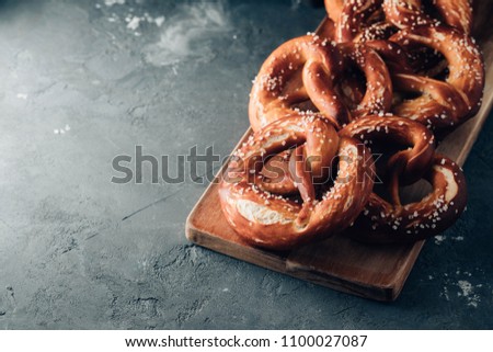 Freshly baked homemade soft pretzel with salt on rustic table. Perfect for Octoberfest. Toned image.
