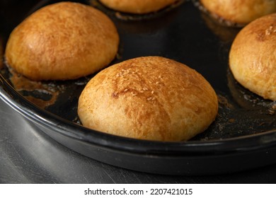 Freshly baked hot burger buns in an industrial oven - Shutterstock ID 2207421015