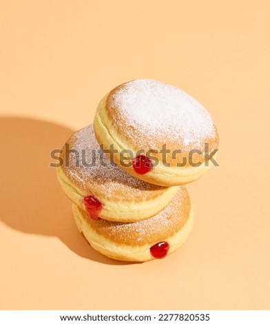 freshly baked jelly donuts on orange color background