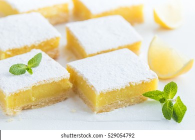 barres de citron fraîchement cuites (ou carrés de citron) avec du sucre en poudre sur fond blanc, mise au point sélective