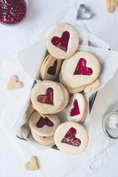 Freshly Baked Linzer Cookies In A Loaf Tin Set Against A White Background. Jam, Cookie Cutters, Heart Shaped Biscuits Included In Frame. Flat Lay Style. Love, Romance And Valentines Day Food Concept