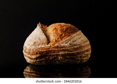 freshly baked loaf of artisan whole wheat rustic sourdough bread on black background . food healthy concept. - Powered by Shutterstock