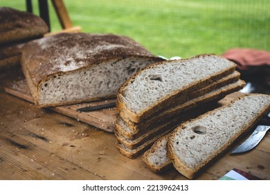 freshly baked loaf of rye bread, sliced, cut out with a knife, close up