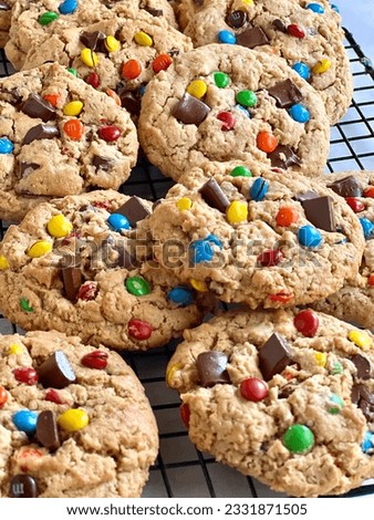 Freshly baked monster cookies on a wire cooling rack
