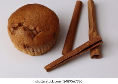 Freshly baked muffin with cinnamon sticks on a plain white background. - Powered by Shutterstock