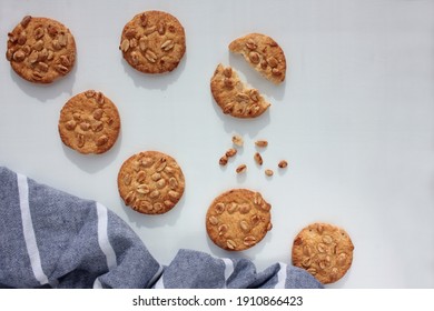 Freshly Baked Peanut Cookies On A White Background With Striped Gray Cloth Napkin. Overhead View, Selective Focus