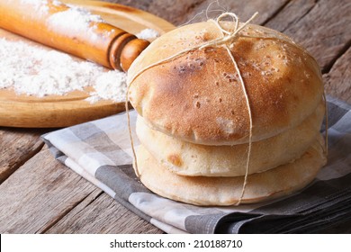 freshly baked pita bread on a wooden table close-up. rolling pin and flour in the background. horizontal  - Powered by Shutterstock