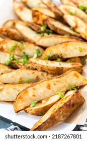 Freshly Baked Potato Wedges With Spices On A White Serving Tray.