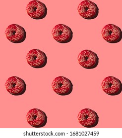 Freshly baked raspberry donuts for breakfast on a pink background . Sweet background