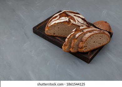 Freshly baked rye bread on brown cutting board. Healthy yeast-free bread, Place for text.