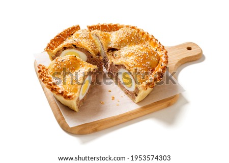 Freshly baked a showstopping raised pie using sausagemeat and boiled eggs isolated on white background
