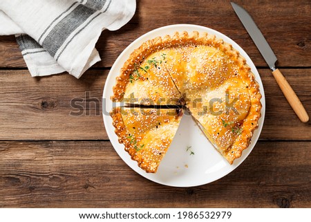 Freshly baked a showstopping raised pie using sausagemeat and boiled eggs on wooden background. top view	