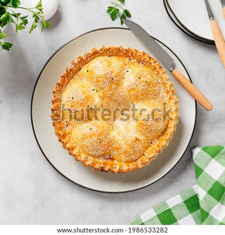 Freshly baked a showstopping raised pie using sausagemeat and boiled eggs on light gray background, top view.