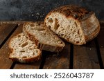 Freshly baked sourdough bread is beautifully sliced and artfully displayed on a charming rustic wooden surface