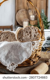 Freshly baked sourdough bread in a rustic basket with a rolling pin and white flowers, showcasing organic ingredients, artisan craftsmanship, premium bakery quality, and cozy kitchen warmth