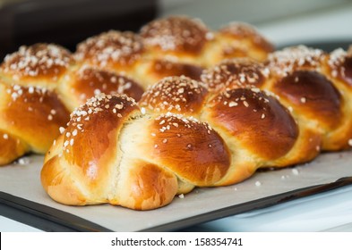 Freshly baked sweet braided bread loaf on a baking sheet, shallow depth of field 