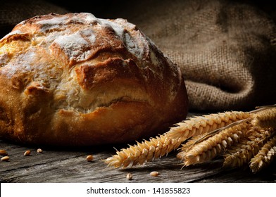 Freshly baked traditional bread on wooden table - Powered by Shutterstock