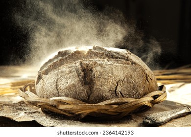 Freshly baked traditional bread in a sprinkle of flour. Yeast-free rye bread on the kitchen table, close-up. Food background. Rustic style.