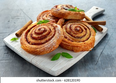 Freshly Baked Traditional Sweet Cinnamon Rolls, Swirl on white wooden board.