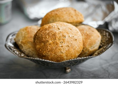 Freshly baked whole grain breakfast rolls from ready-made dough, rustic and hearty, served on a kitchen table. Healthy start to the day with homemade flavor