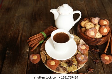 freshly brewed black coffee in a white cup with a saucer and a white kettle with heart-shaped cookies on a rustic wooden table with space for text - Shutterstock ID 1281769414