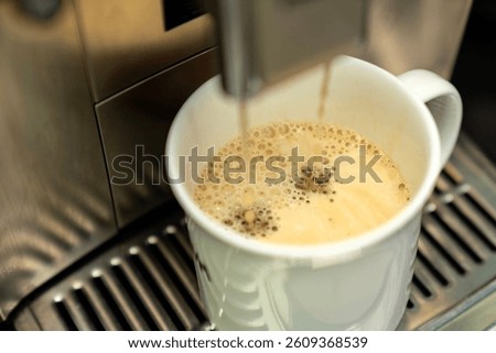 Freshly Brewed Coffee in Mug from Espresso Machine. Hot Morning Beverage with Creamy Foam, Caffeine Boost. Making ground coffee from coffee beans barista Style Drink at Home or Café break Concept, 