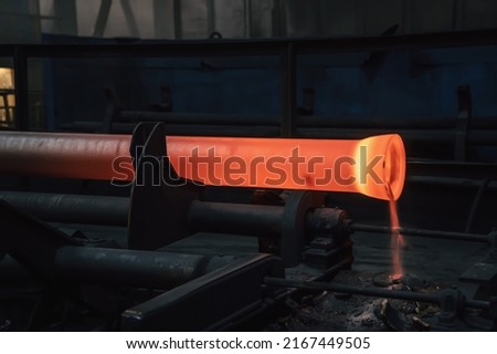 Freshly cast hot cast iron pipes at smelter. Manufacture of pipes for water, gas or oil