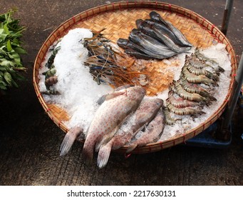 Freshly caught fish and shrimp in a wicker basket in ice, morning fish market, Myanmar (Burma)