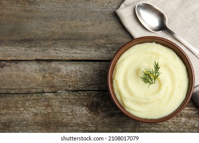 Freshly cooked homemade mashed potatoes with spoon and napkin on wooden table, top view. Space for text - Shutterstock ID 2108017079