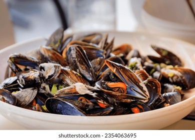 Freshly cooked mussels steamed in white wine sauce or moules marinieres on a plate at a restaurant in Nice Old Town, French Riviera, South of France