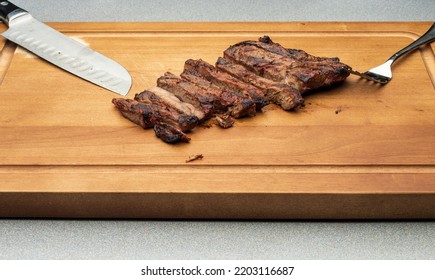 A Freshly Cooked New York Strip Steak Cut On A Acacia Cutting Board