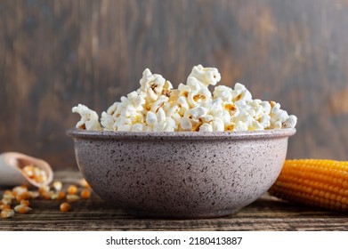 Freshly cooked popcorn in a bowl on a wooden table. Traditional American maize snack. - Powered by Shutterstock