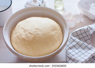 Freshly cooked yeast dough in ceramic bowl on white wooden table, selective focus