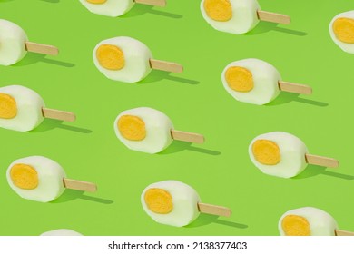 Freshly Cut Easter Egg With Ice Cream Stick Pattern Against Green Background. Creative Food Or Holiday Concept.