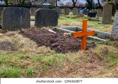 A Freshly Dug Grave In A Graveyard