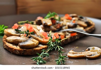 Freshly fried mushrooms are caught on a languid bread with butter. is presented on a bowl with natural light.
