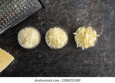 Freshly Grated and Shredded Parmesan Cheese in Glass Prep Bowls: Three different textures of grated and shredded parmesan cheese with a box grater - Powered by Shutterstock