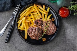 Freshly Grilled Beef Steak Meat And French Fries On Black Plate, Top View