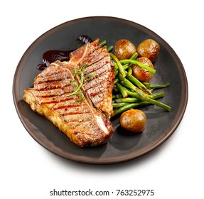 Freshly Grilled T Bone Steak And Vegetables On Dark Plate