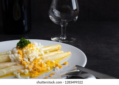 Freshly homemade White asparagus with butter and boiled eggs on a white plate.