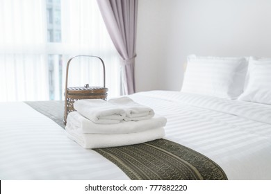 Freshly Laundered Fluffy Towels On Bed In Hotel