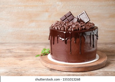 Freshly made delicious chocolate cake on wooden table. Space for text - Shutterstock ID 1551013268