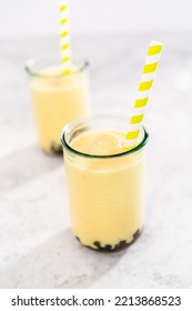 Freshly Made Mango Boba Smoothie In A Drinking Glass With A Paper Straw.