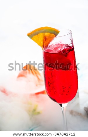 Freshly made red cocktail with a slice of lemon