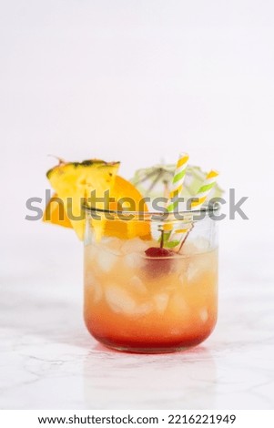 Freshly made Sunset cocktail garnished with a slice of fresh orange and pineapple.