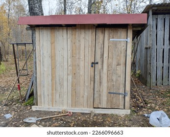 Freshly made unpainted wooden shed with red roof - Shutterstock ID 2266096663