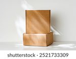 Freshly packed cardboard boxes resting on a white surface, illuminated by soft natural light